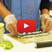 hands rolling sushi with video icon