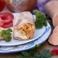 burrito on plate with vegetable ingredients