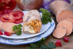 burrito on plate with vegetable ingredients