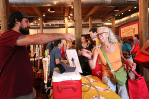 a woman is handed a beer at Curds and Crafts