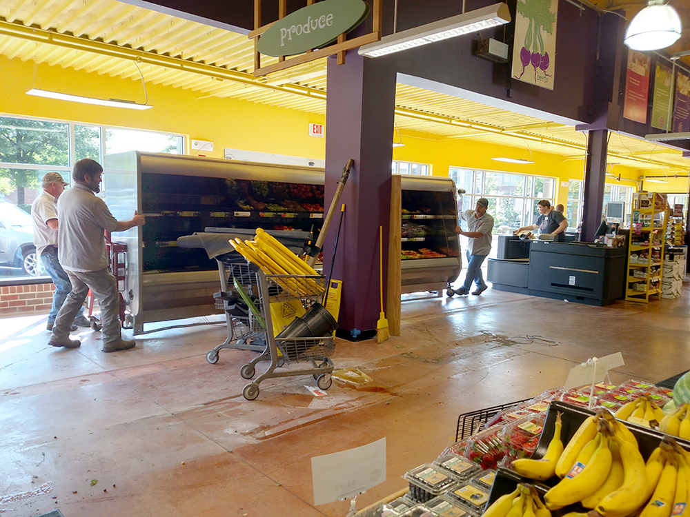 men moving produce cooler in store