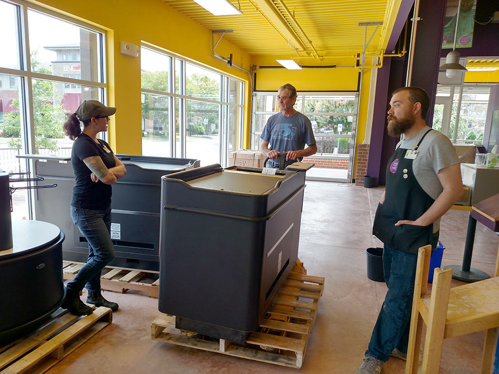 people talking around a cash register counter