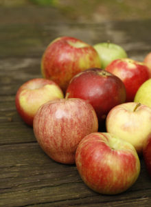 group of local apples on a wooden floor