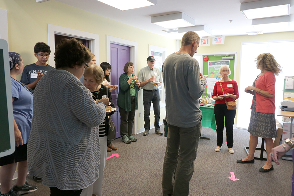 Brenda explains the hunger relief programs to a circle of visitors
