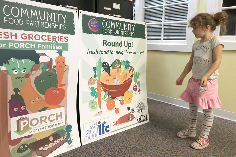 A girl reads posters about hunger relief programs
