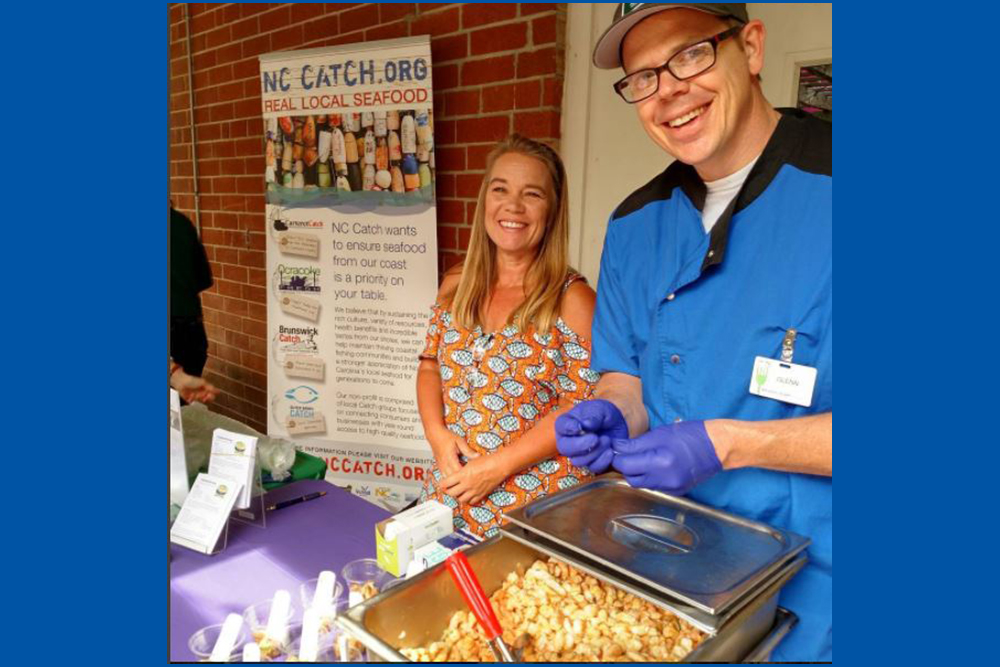 Glenn and a woman with a pan of shrimp
