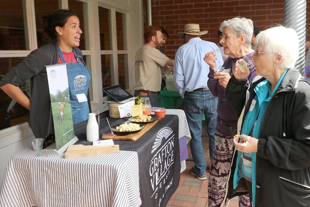 Two women eat samples of cheese at a table