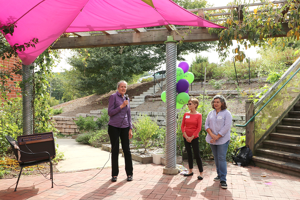 Alice talks on microphone while Linda and Alicia listen