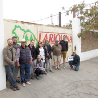 group of people posing outside the winery
