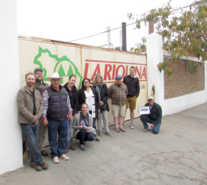 group of people posing outside the winery