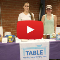 two women at table labeled "TABLE" with video icon