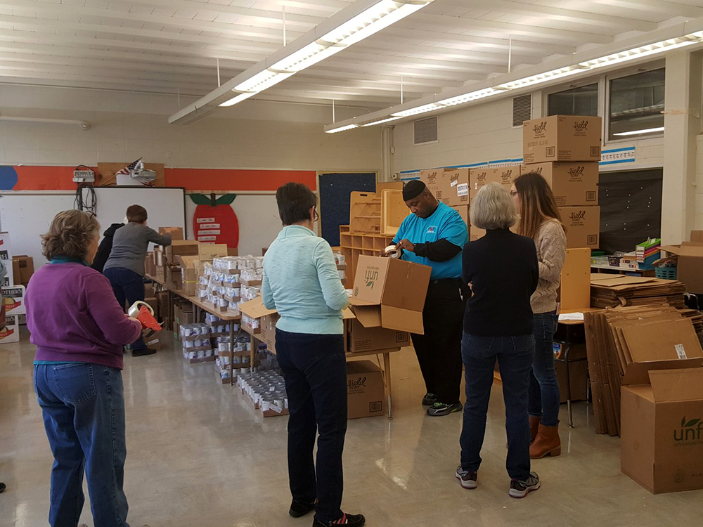 volunteers sorting food in a classroom