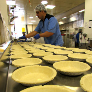 Leo scooping filling into pot pies