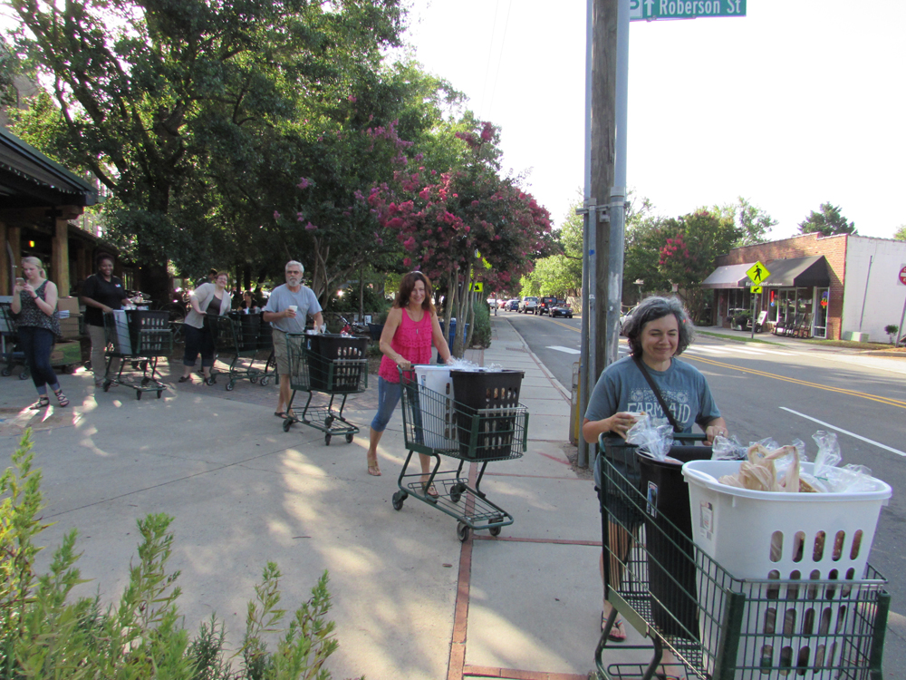 people push shopping carts down sidewalk