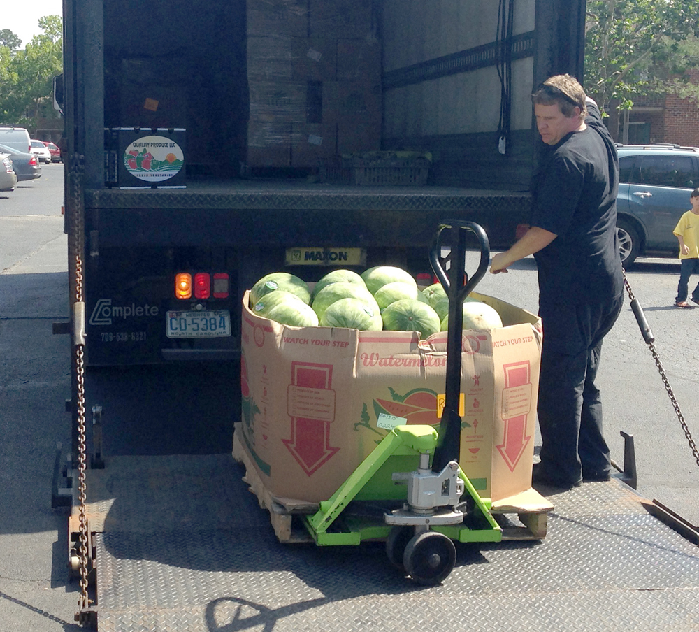 Errol taking a pallet of watermelons off the truck