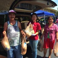 People accepting bags of groceries