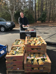 man loading a pallet of pineapples