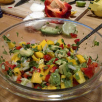 bowl of salsa with avocado, mango, red pepper, and cilantro