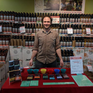 man behind a table with chocolate samples