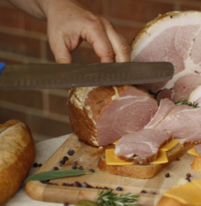 hands cuttign small ham