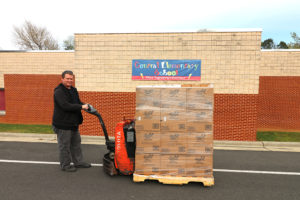 Errol with a pallet of food boxes outside a school