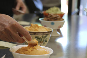hand scooping hummus