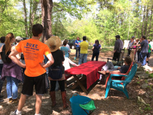 group of people standing under trees