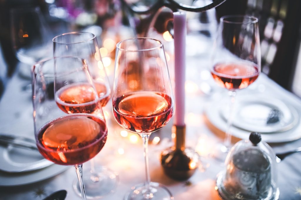 rose wine in glasses on a dinner table with a candle