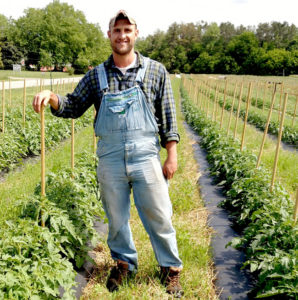 farmer in field with tomato plants