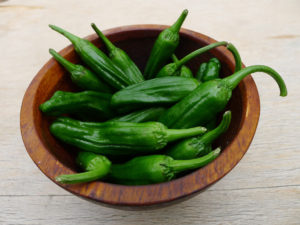 wooden bowl of small shishito peppers