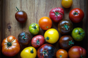 tomatoes with various colors on wooden surface