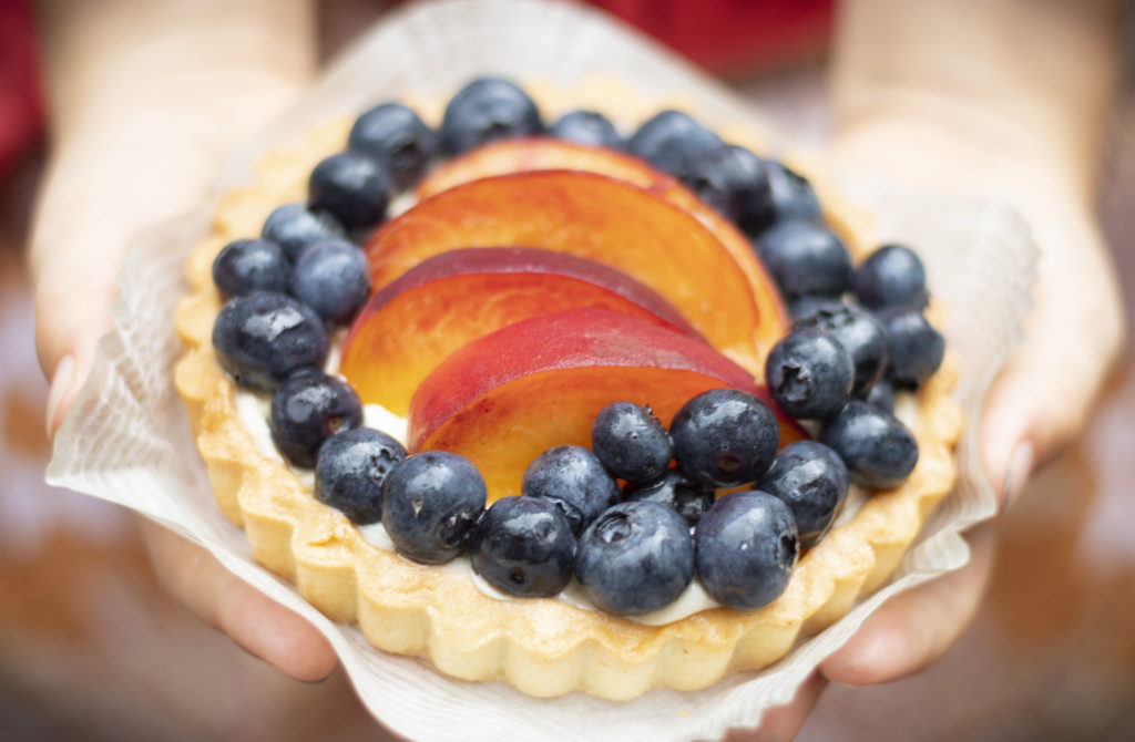 small peach tart in child's hands