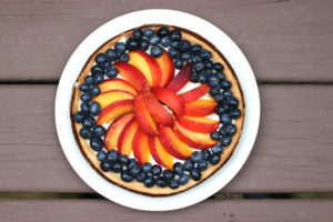 large peach tart with blueberries around the edge, seen from above