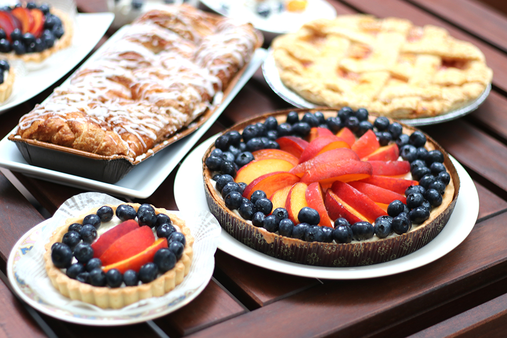 peach tart, pie, coffeecake, and shortcakes on wooden slats of table