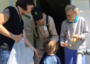 woman and child deliver food to two older adults
