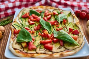 Pizza with red peppers and basil on top