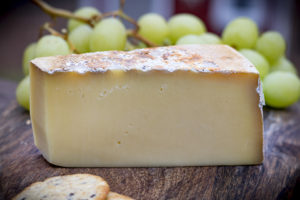 a block of cheese with grapes