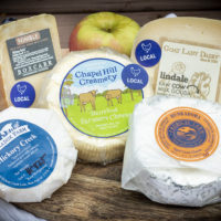 5 cheeses on a board, with labels from North Carolina cheese-makers