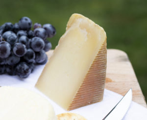 a wedge fo cheese with grapes