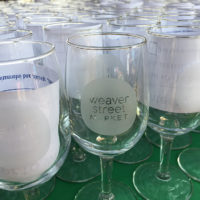 wine glasses etched with Weaver Street logo on table