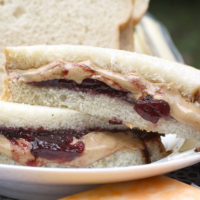 close up of peanut butter and jelly sandwich on white bread