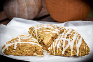 three scones with lines of icing drizzled across the tops