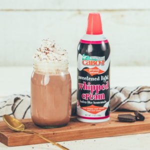 Cabot can of whipped cream and chocolate drink in glass with whipped cream on top