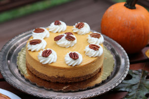 pumpkin cheesecake with whipped cream and nuts on top