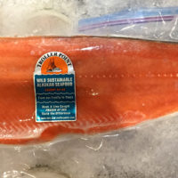 long side of salmon wrapped in plastic, on ice