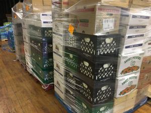 boxes of food wrapped in plastic, on a pallet, in a warehouse