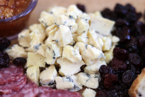 crumbles of blue cheese on a cheese board