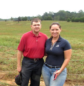 two people standing in a grassy field