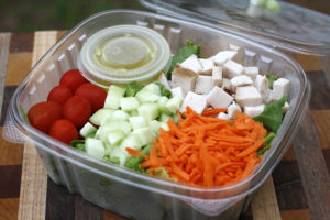 salad with tomatoes, cucumber, carrots, and turkey cubes on top