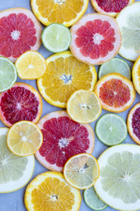 slices of lemons, limes, grapefruit, and many varieties of orange, spread out flat on a table